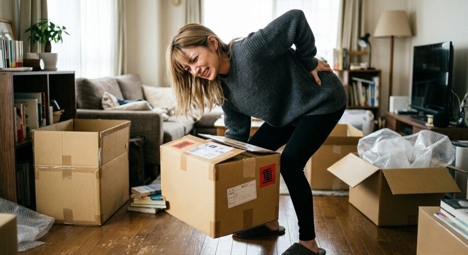 荷物を持ち上げた際にぎっくり腰になった女性のイメージ
